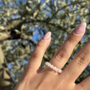 Rosenquarz Ring mit facettierten 4 mm Edelsteinen vor einem Olivenbaum in der Abendsonne